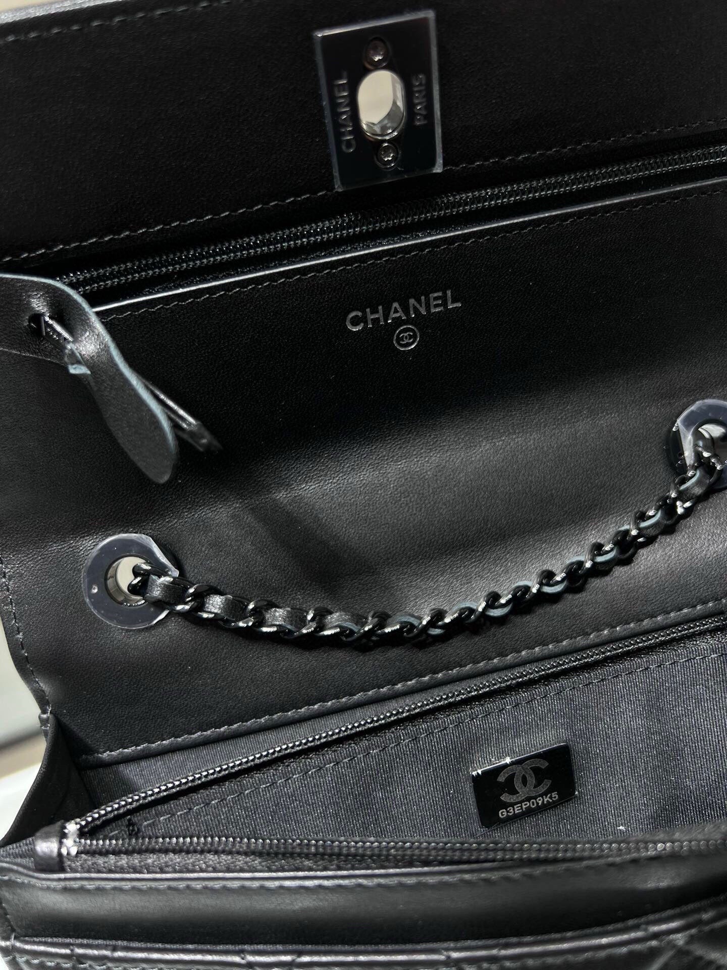 Black leather bag interior with zipper, CHANEL logo, and chain strap