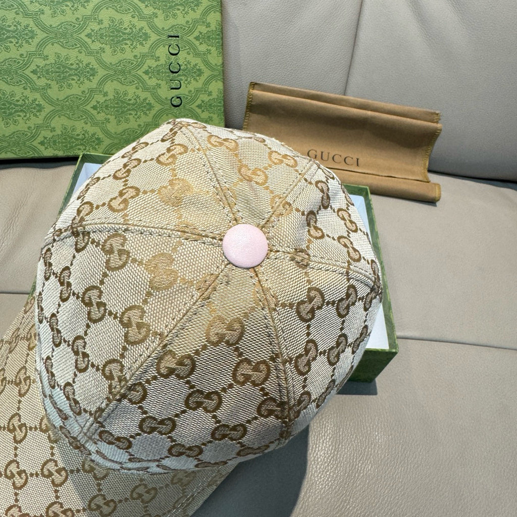 Gucci cap front view in beige GG monogram canvas with pink round top button.