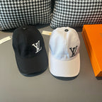 Two caps: black and white Louis Vuitton baseball caps with LV monograms