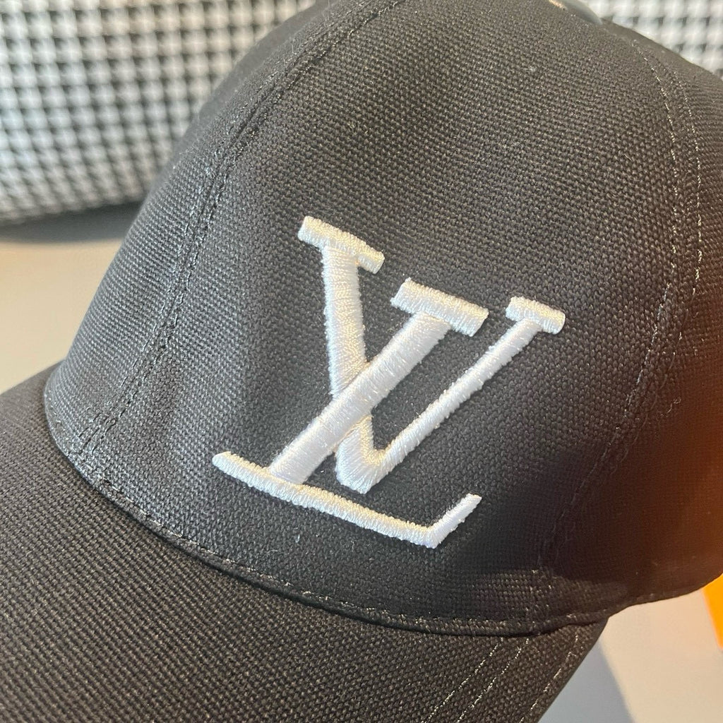 Close-up of black Louis Vuitton baseball cap with white LV monogram