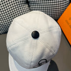 White Louis Vuitton cap with curved seams and black button at the crown