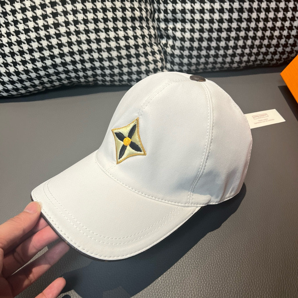 Louis Vuitton white baseball cap with embroidered star emblem, angled close side view