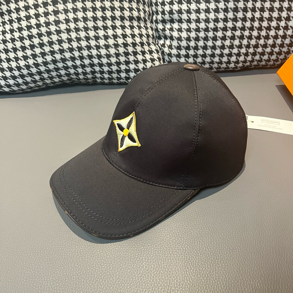 Louis Vuitton cap in dark fabric with yellow-and-black emblem near crown seam.