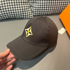 Louis Vuitton cap in dark fabric with yellow-and-black emblem, shown from side angle.