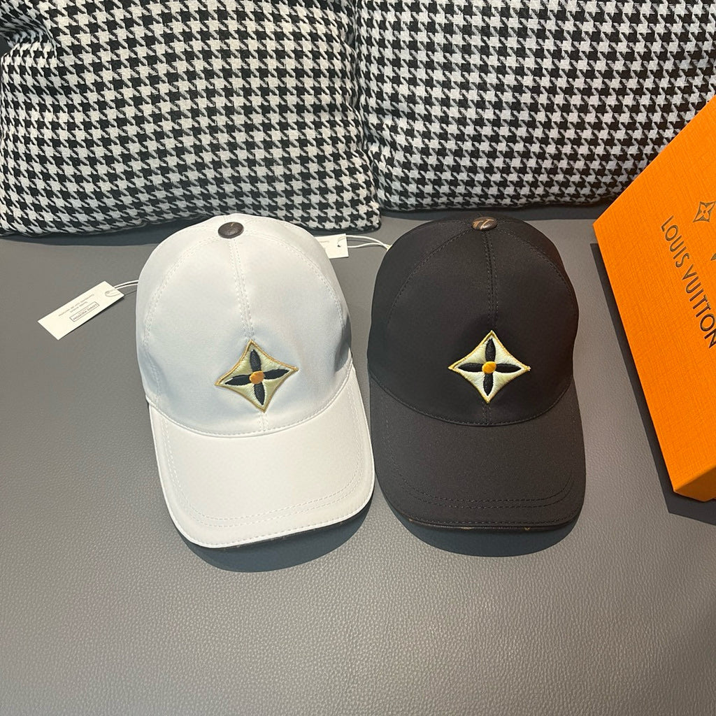Louis Vuitton cap pair: white and dark styles with yellow-and-black emblem front.
