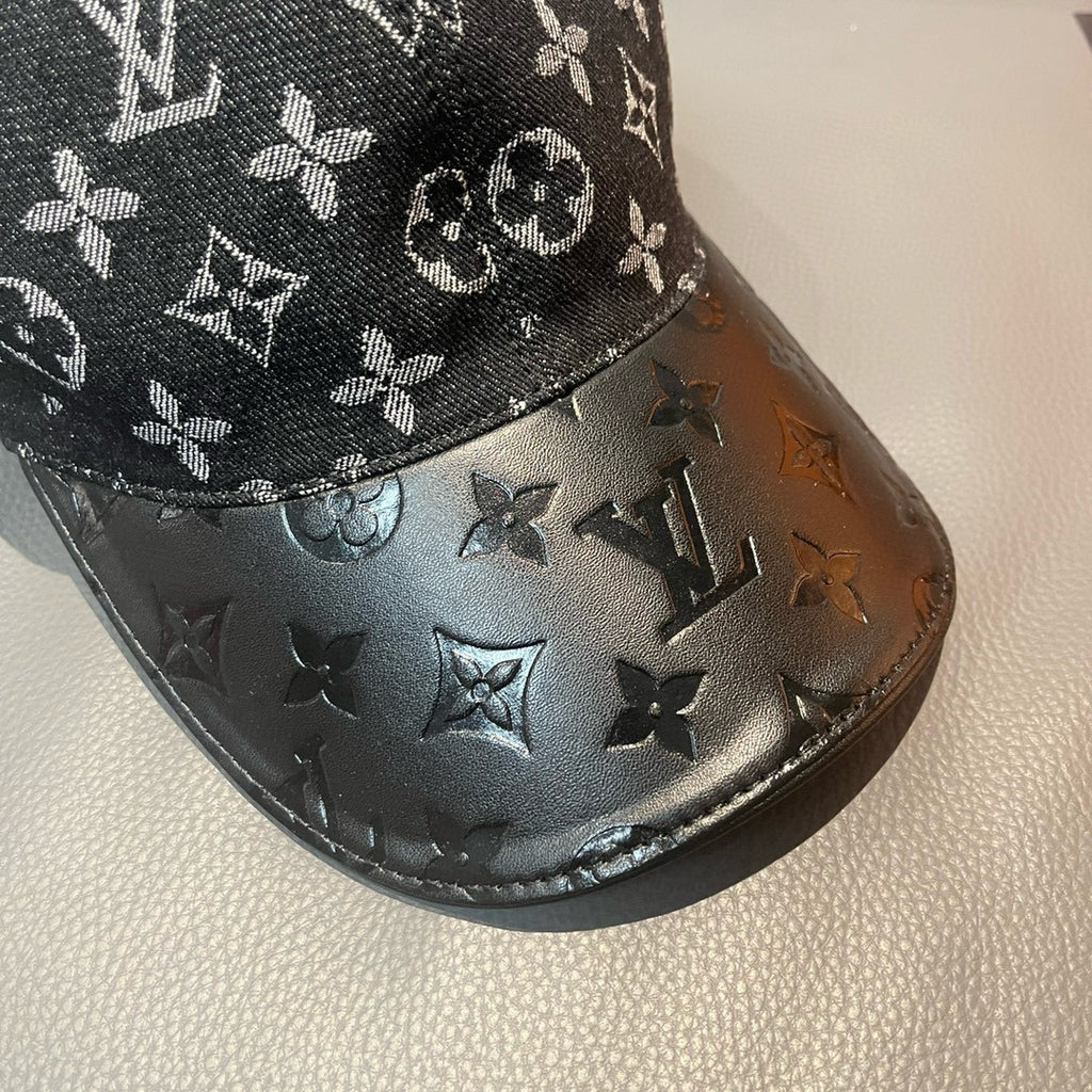 Close-up of Louis Vuitton monogram cap brim with dark leather-like finish and logos