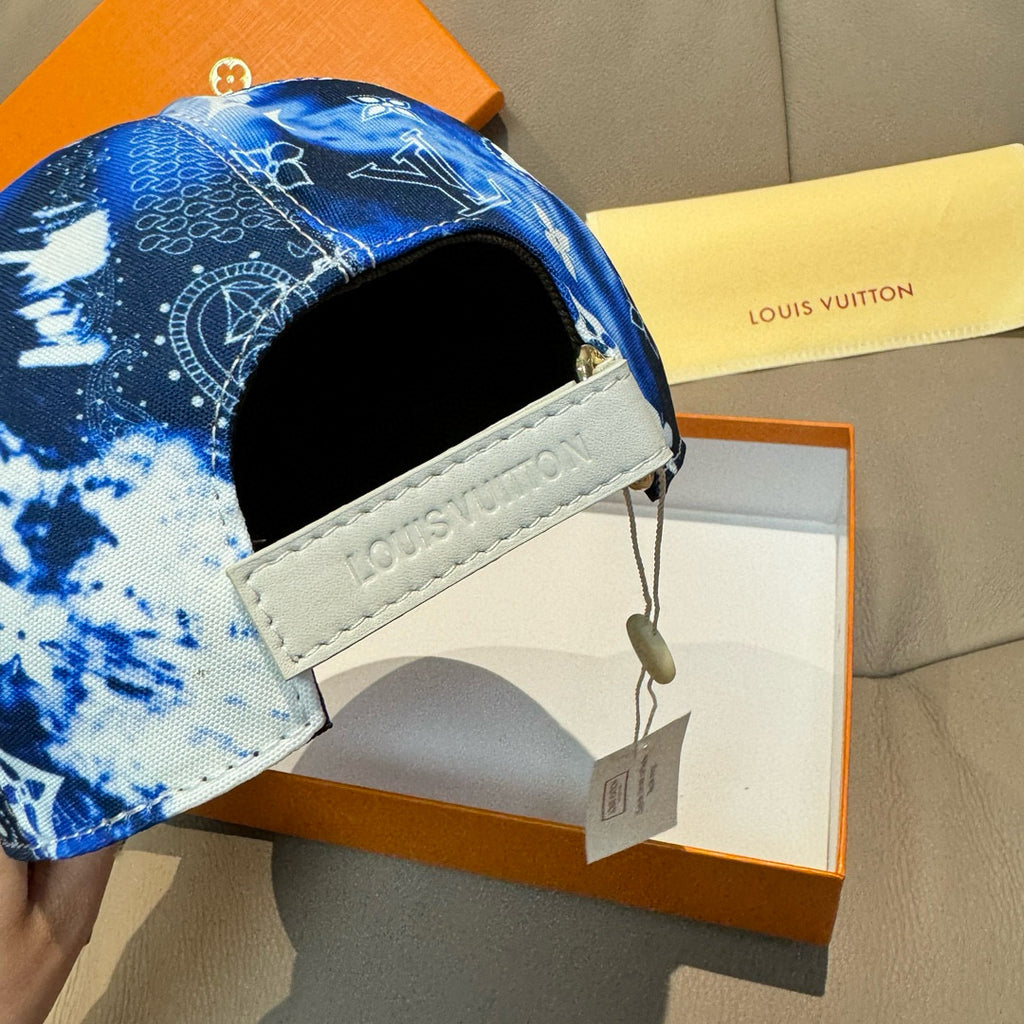 Louis Vuitton cap side with white leather band, hanging tag, blue monogram fabric.