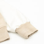 Beige bomber jacket sleeve cuffs with ribbed knit and white inner lining