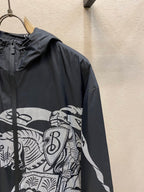 Hooded jacket sleeve close-up with black fabric and white graphic panel