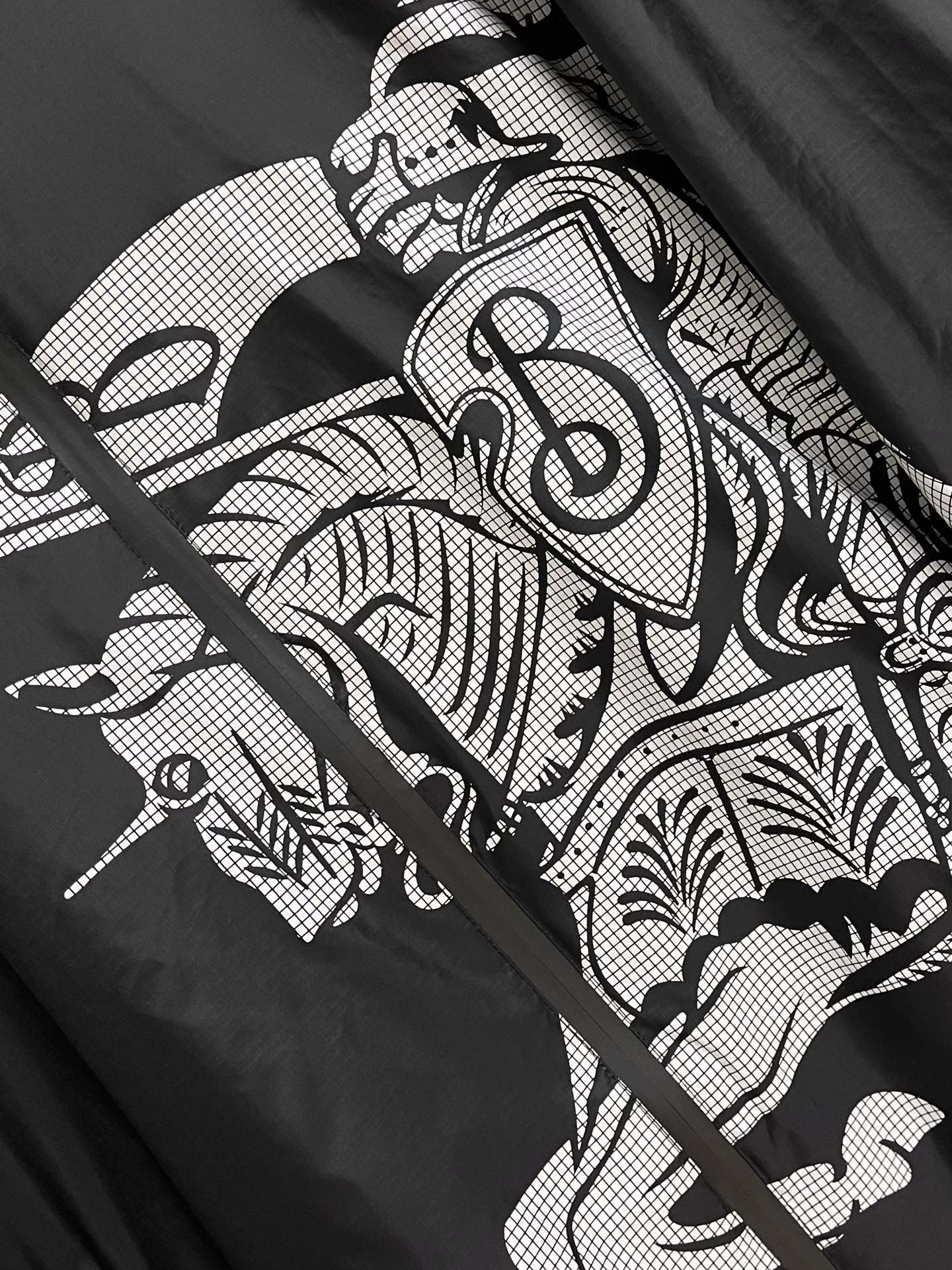 Close-up of black jacket with white graphic pattern and lines