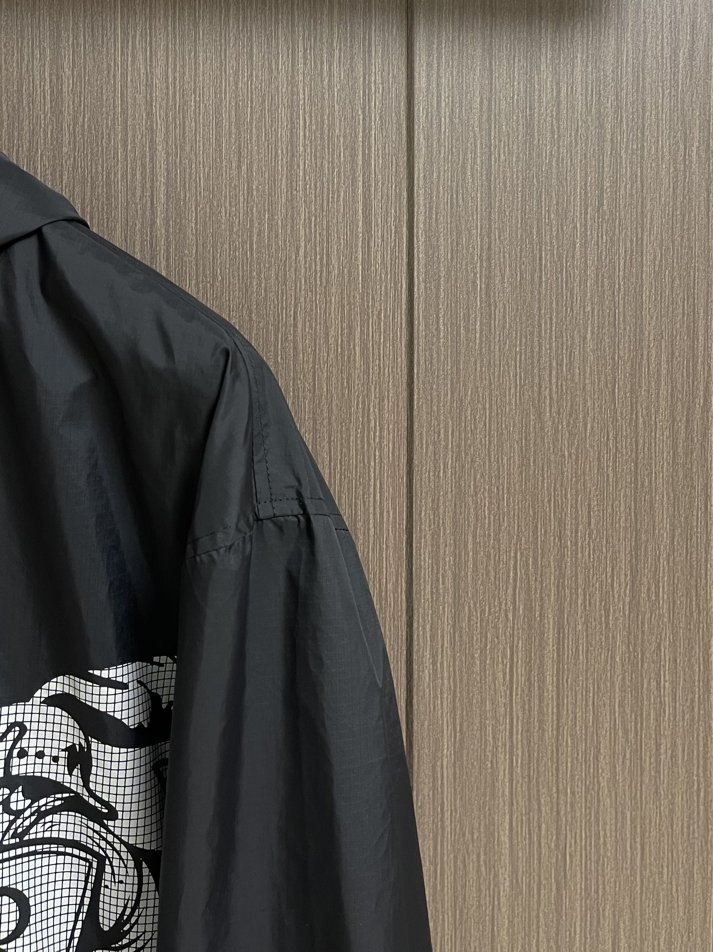 Black jacket sleeve and side panel with white graphic print