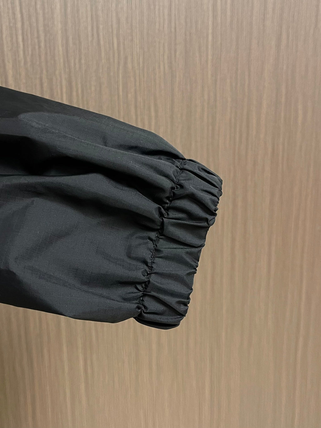 Black jacket sleeve end with elastic, gathered cuff