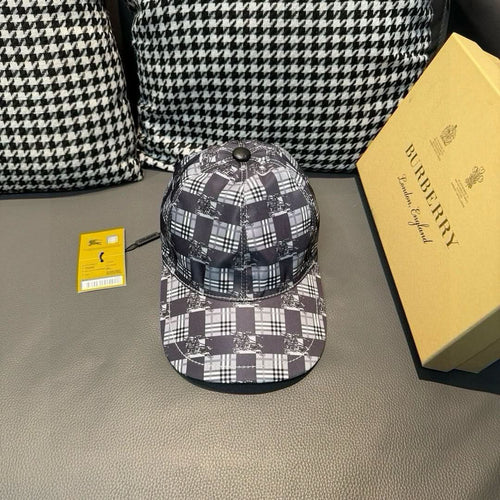 Burberry checkered cap in black, white, and dark gray plaid with round metal top button.