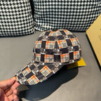 Burberry cap with plaid fabric and curved brim, held in hand for front-left view