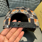 Burberry cap side detail with black strap and snap hardware, underside view