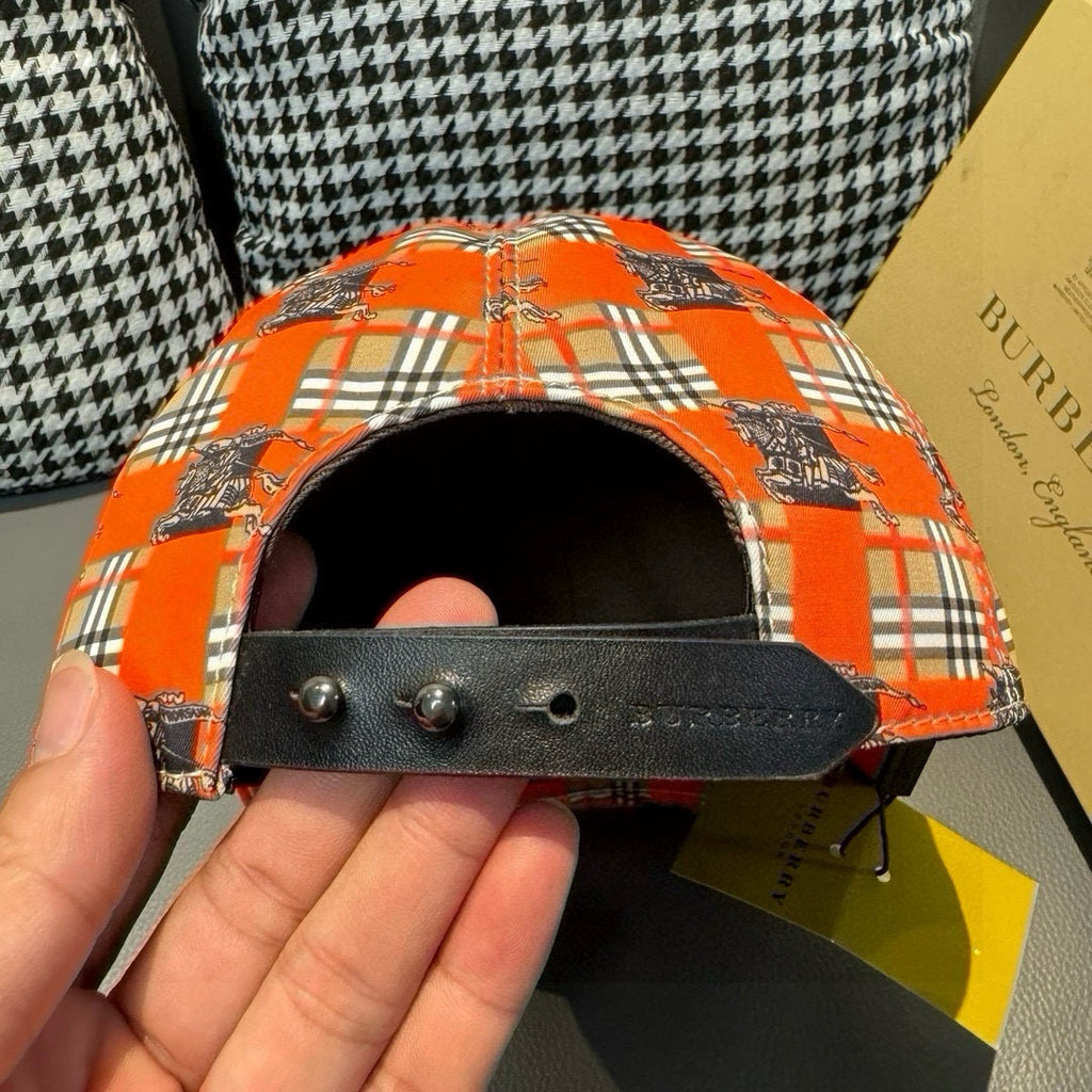 Orange plaid baseball cap showing black strap with metal eyelets inside