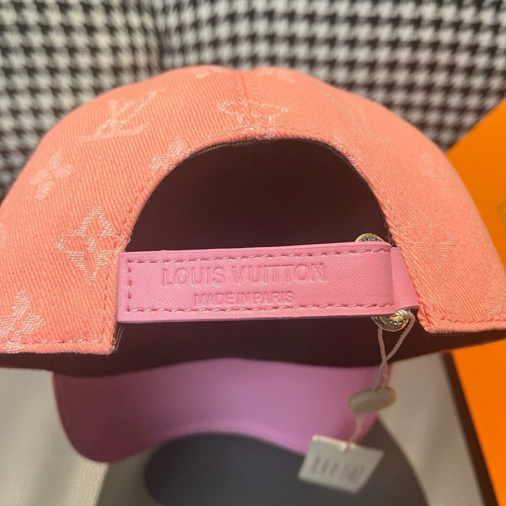 Louis Vuitton monogram cap with adjustable strap, pink label on underside and peach crown.