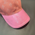 Louis Vuitton monogram baseball cap with pink brim panel under peach crown.