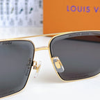 Louis Vuitton sunglasses close-up: gold bridge with dark tinted lenses and metal hinges.