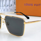 Louis Vuitton sunglasses close-up: gold frame with dark lenses and black temple detail.