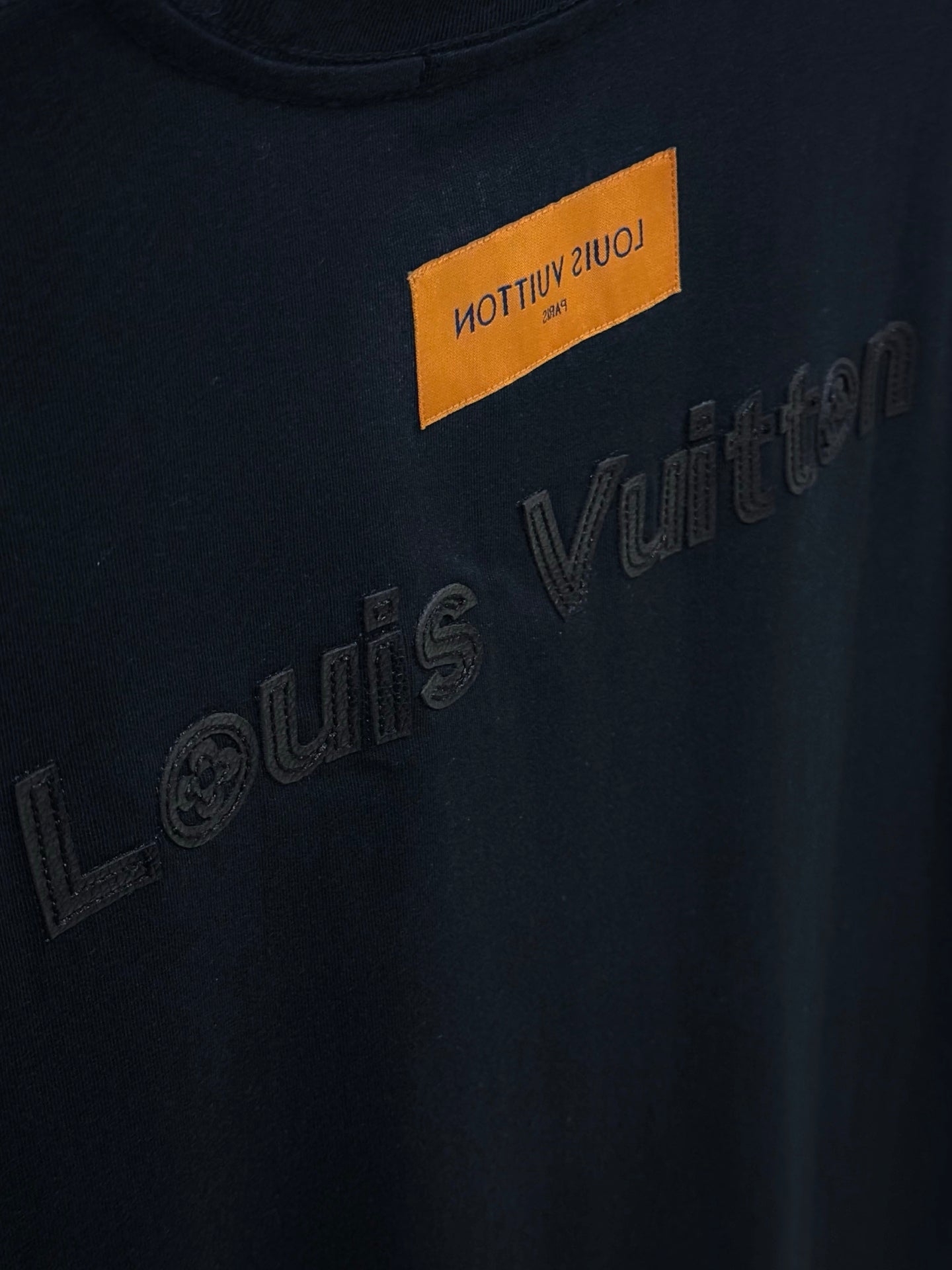 Black T-shirt with Louis Vuitton embossed lettering and orange label
