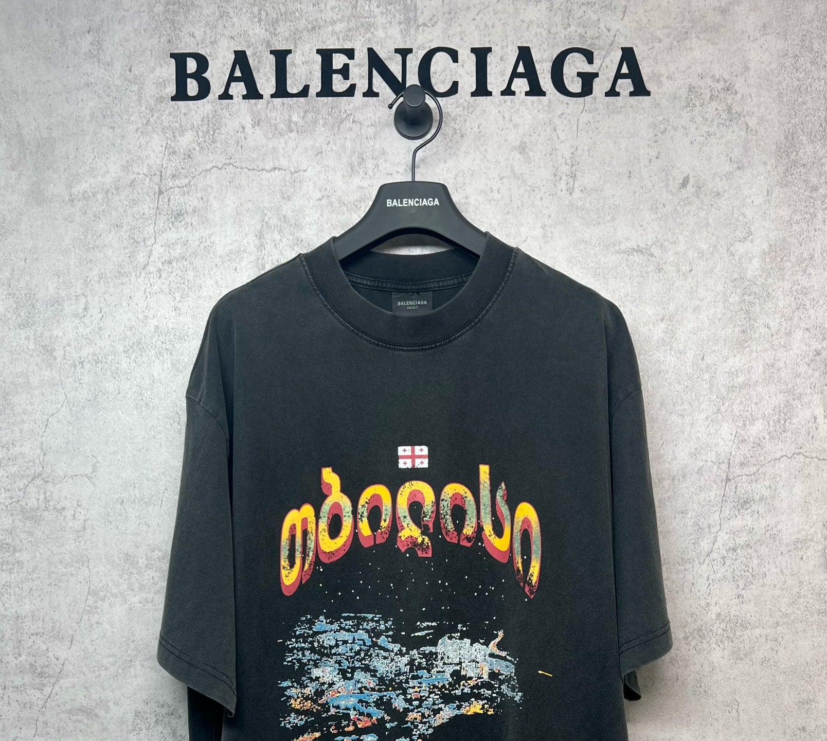Dark gray crew-neck T-shirt with colorful front graphic print and small logo tag