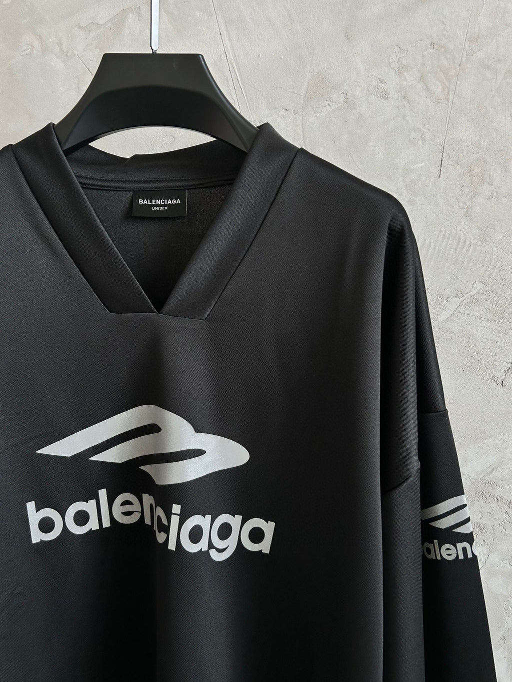Balenciaga long-sleeve V-neck shirt on hanger with front and partial sleeve logo