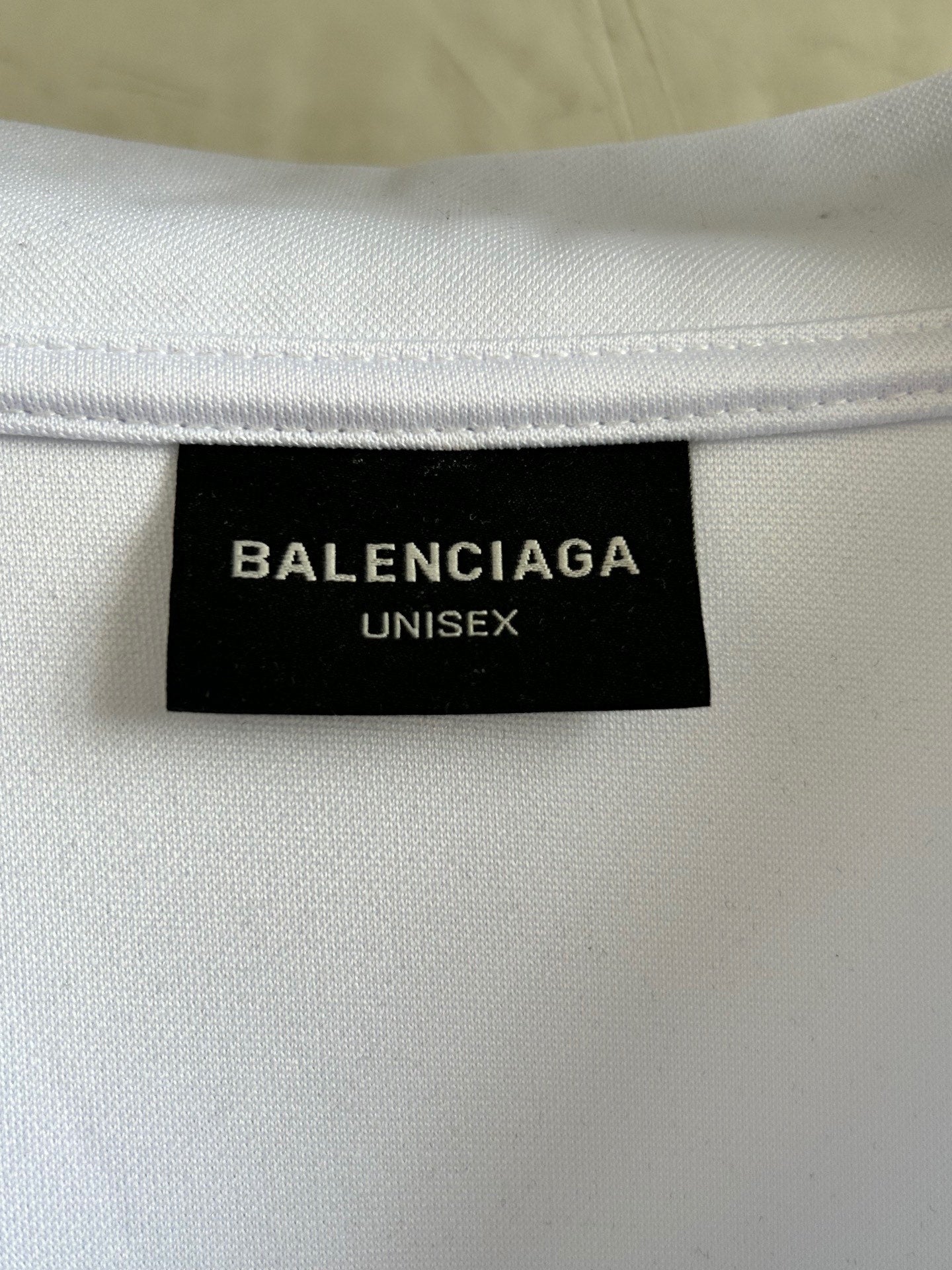Balenciaga UNISEX size label on white long-sleeve V-neck top