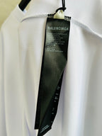 Brand label tag inside neckline on white long-sleeve top with black text