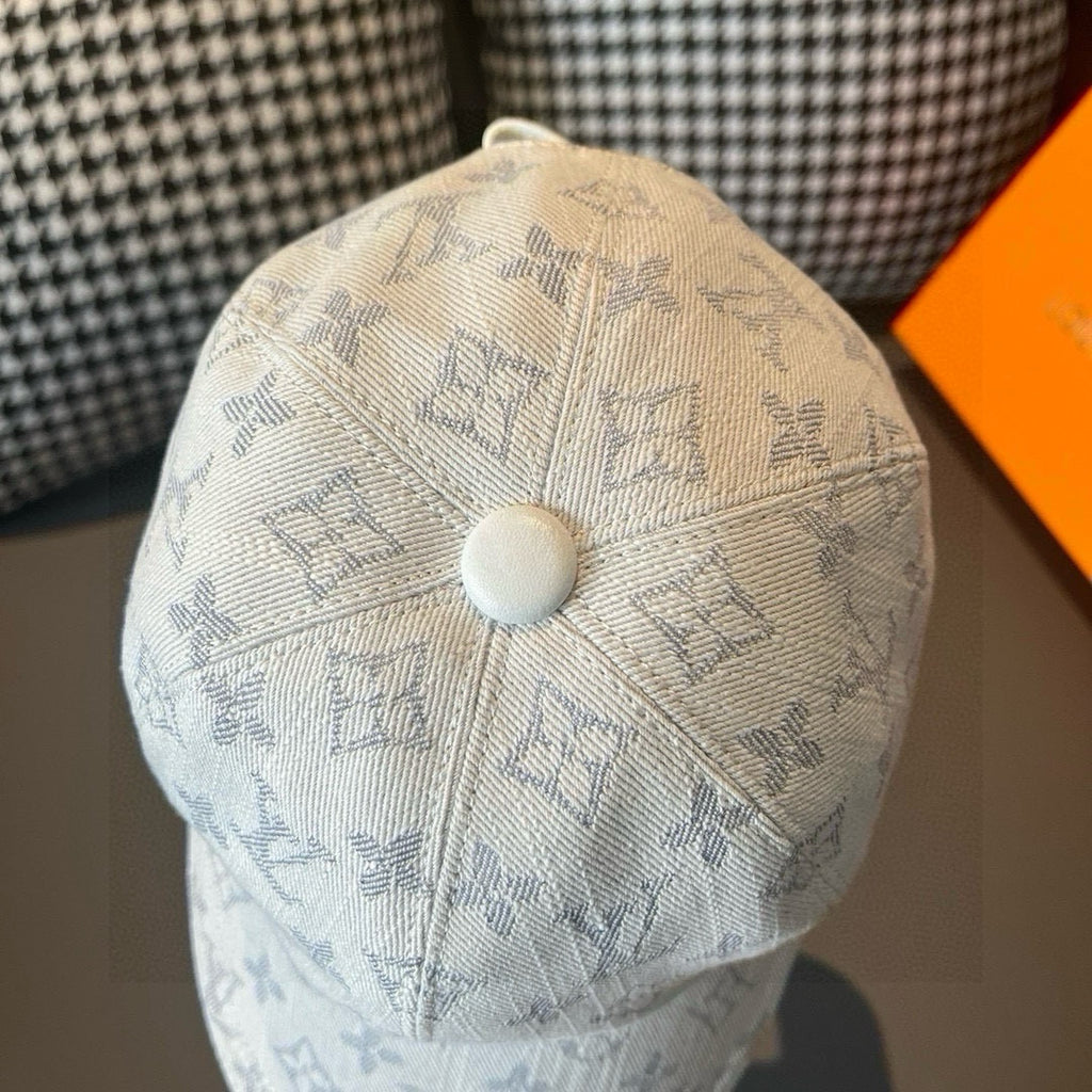 Light beige monogram canvas cap with round top button and blue patterned crown