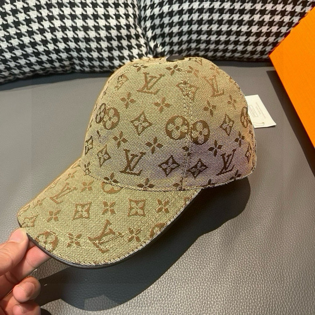Tan monogram baseball cap with curved brim, shown from front-left