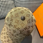 Tan monogram baseball cap with round top button, close-up view