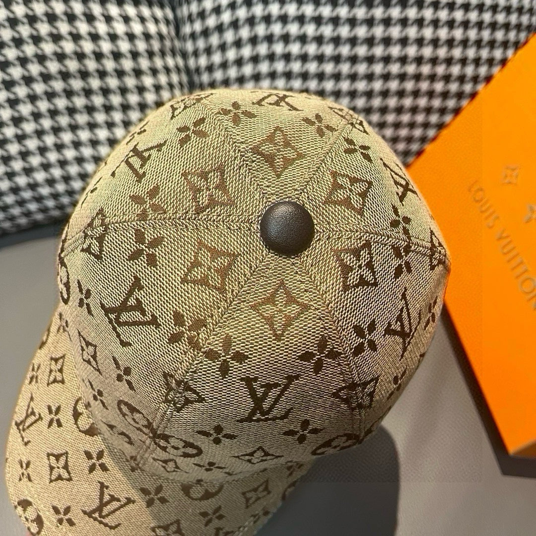Tan monogram baseball cap with round top button, close-up view