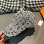 Louis Vuitton cap in light gray with black monogram pattern, held at brim