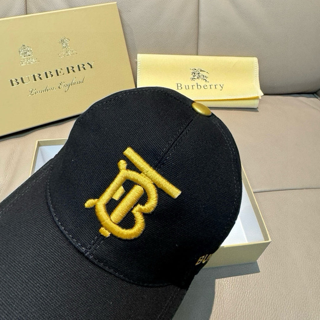 Burberry cap in black with gold TB emblem on the front panel.