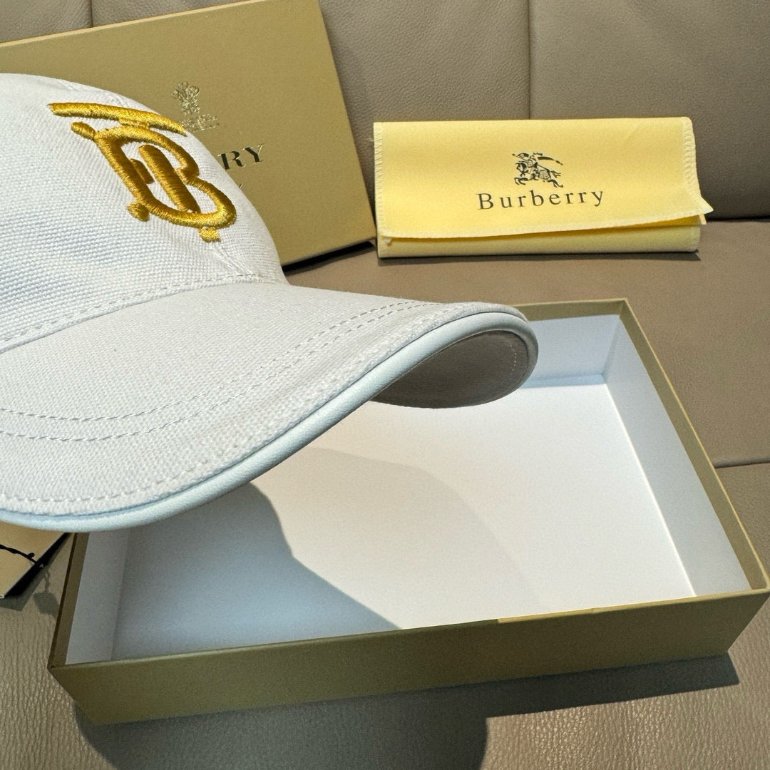 White Burberry baseball cap side view with gold B monogram embroidery