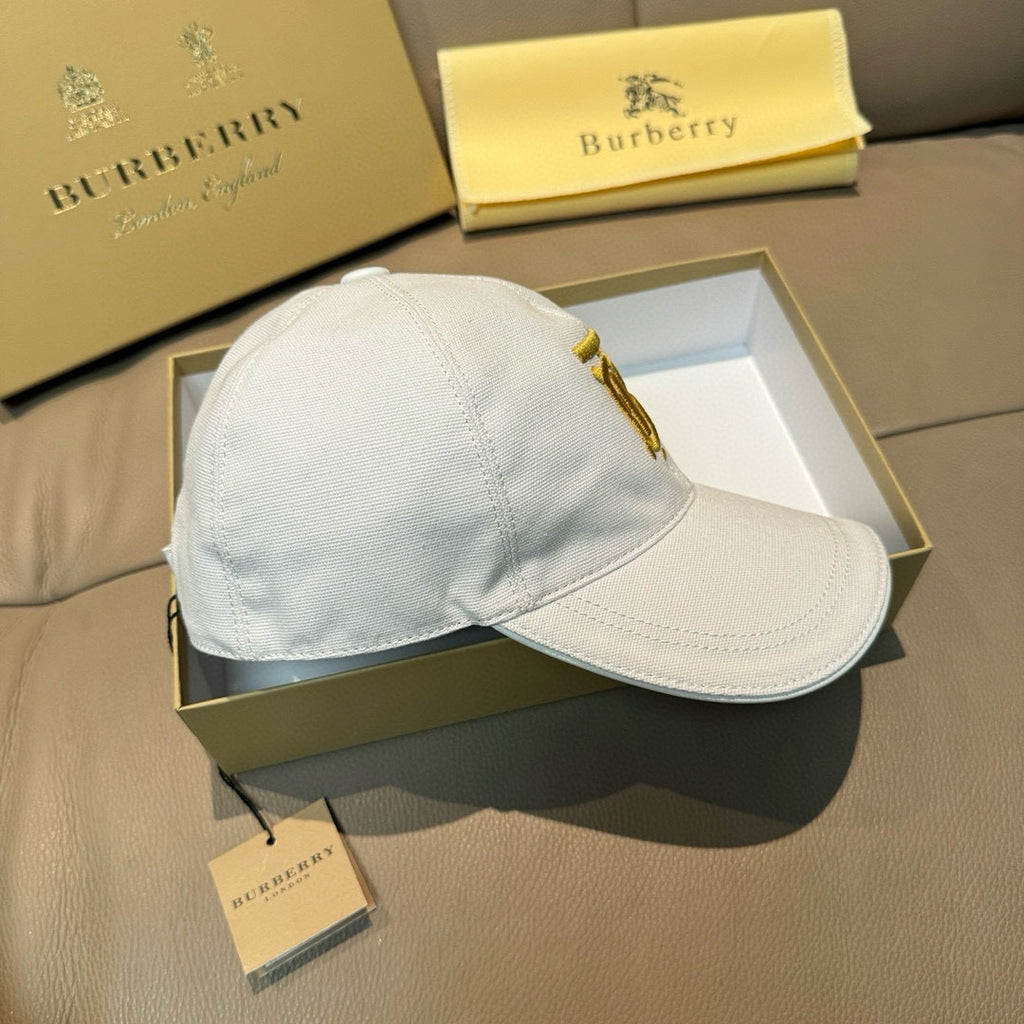 White Burberry baseball cap with gold button cord detail and curved brim