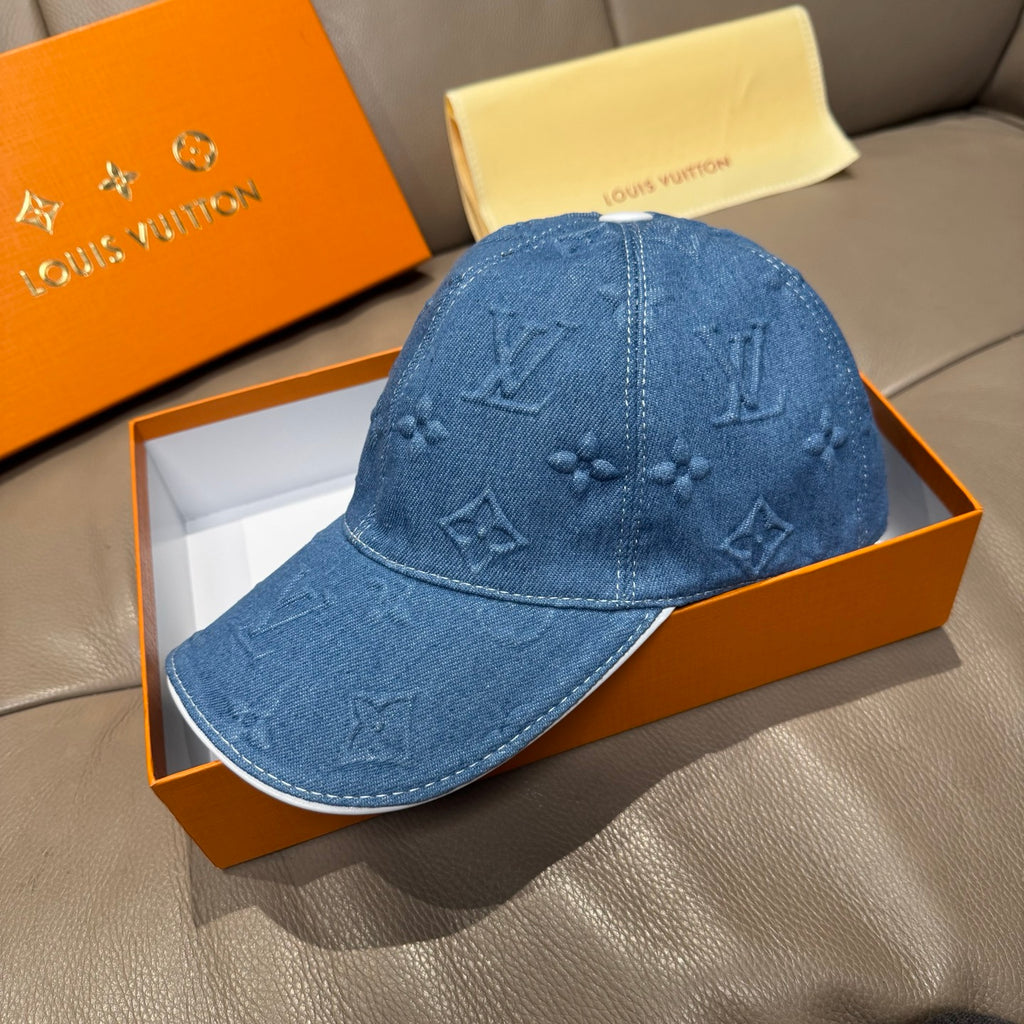Blue denim cap with embossed monogram detailing across front and top seam
