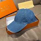 Blue denim cap with embossed monogram detailing across front and top seam