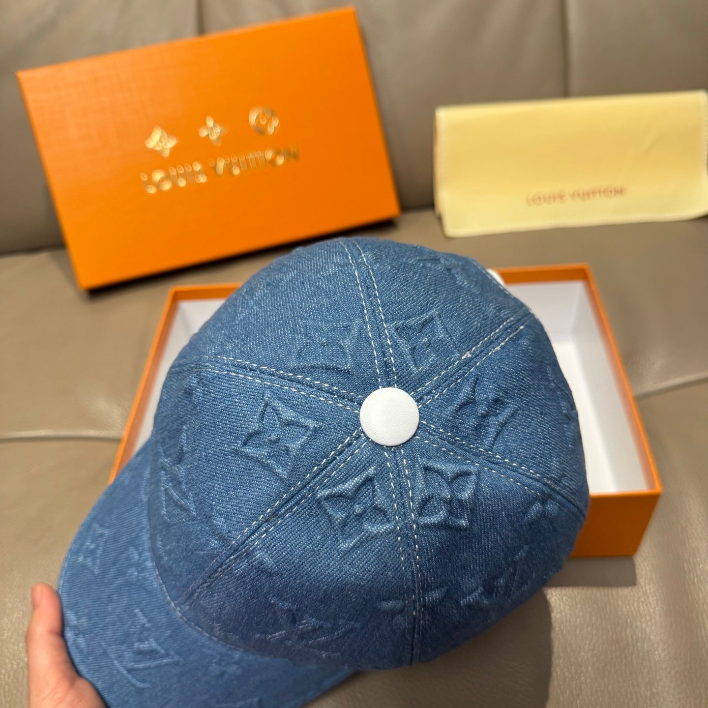 Blue denim cap top with embossed monogram pattern and round white button