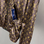 Brown monogram hooded jacket with drawstring waist and fabric tag at neckline