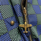 Gold-tone zipper and snap charms on blue-green dotted jacket front