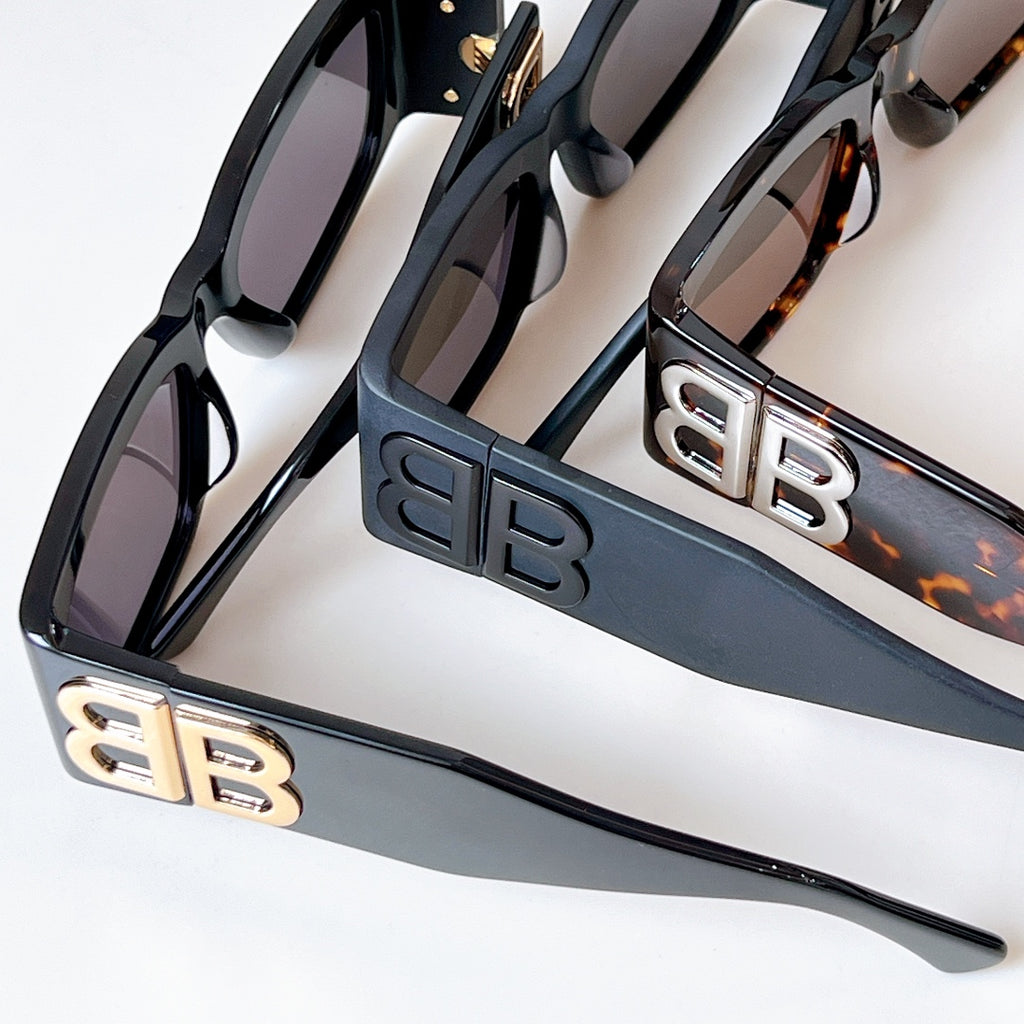 Close-up of black sunglasses with dark lenses and EB logo temple plates