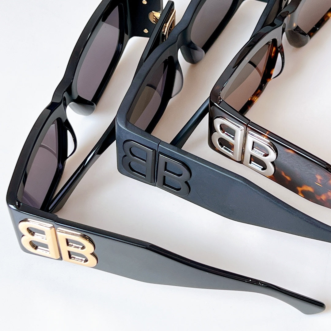 Close-up of black sunglasses with dark lenses and EB logo temple plates
