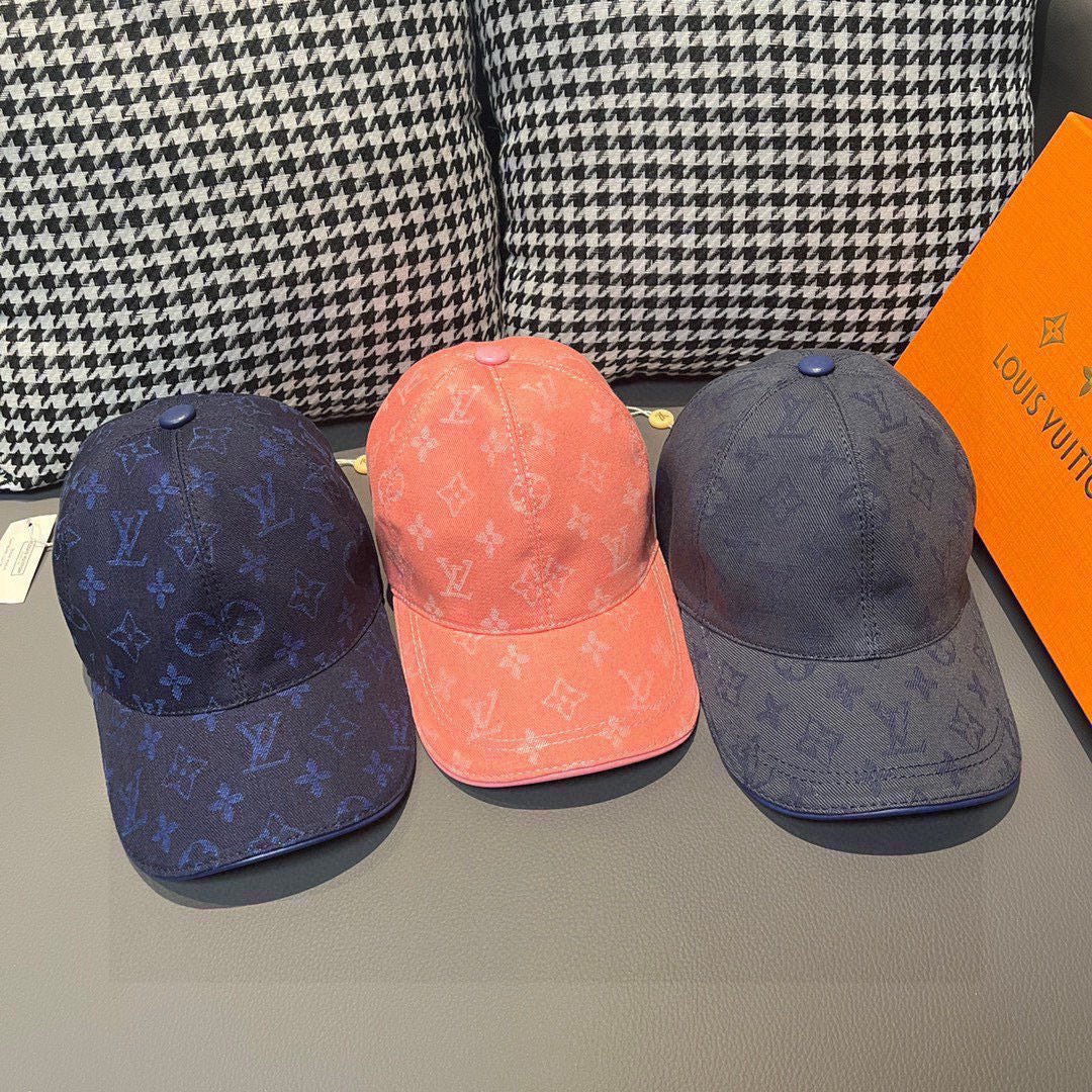 Three Louis Vuitton monogram baseball caps: dark blue, coral, and charcoal blue