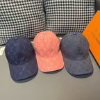 Three Louis Vuitton monogram caps: navy, coral, and dark blue, each with embossed LV pattern