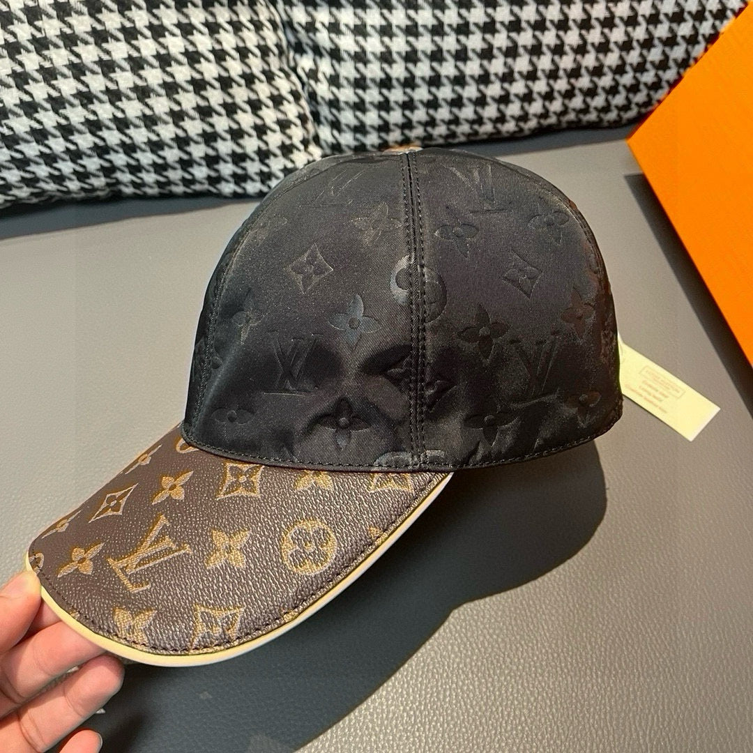 Black monogram baseball cap with brown logo brim; visible top seam
