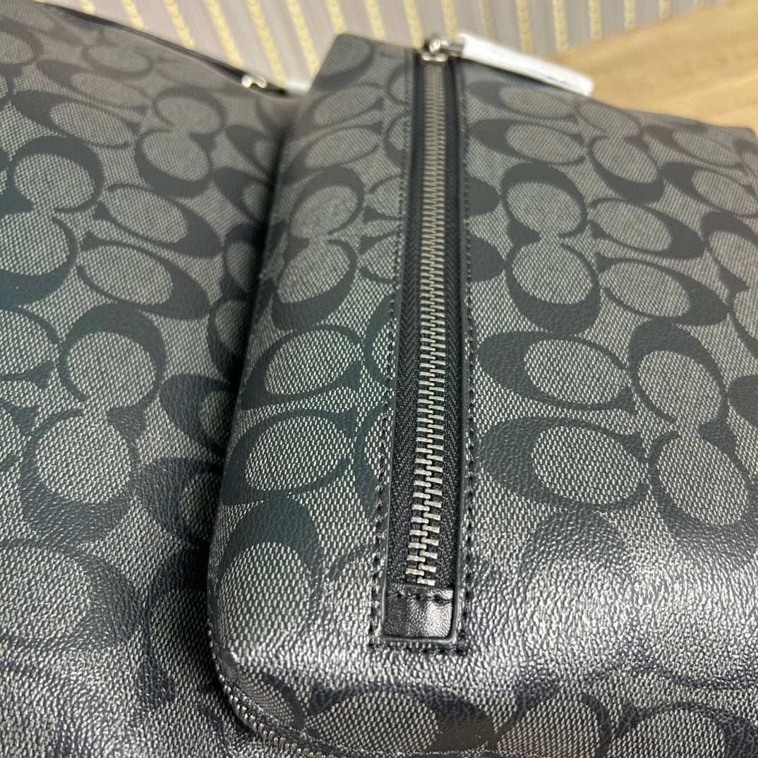 Coah backpack close-up of center zipper and monogram-patterned side panel