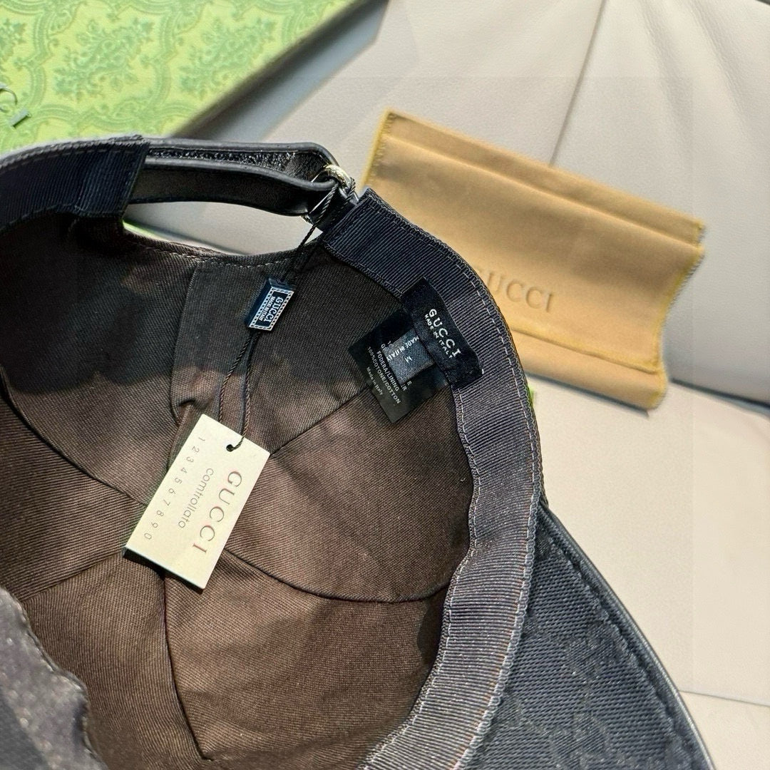 Inside view of black GG monogram cap with fabric lining and hanging tags.