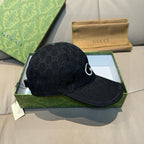 Black GG monogram baseball cap with white swoosh logo on side panel.